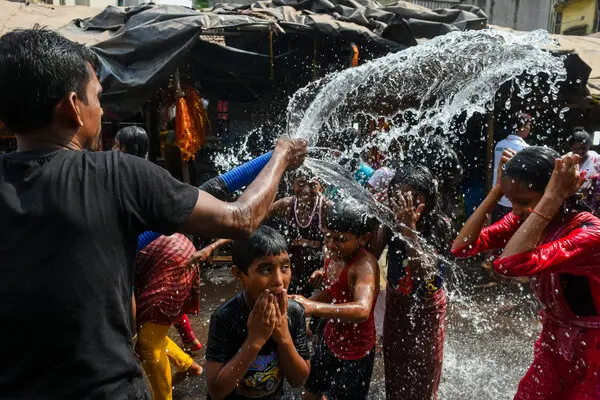 People taking a bath from a municipal tanker on a hot day in Kolkata, India, earlier this month.